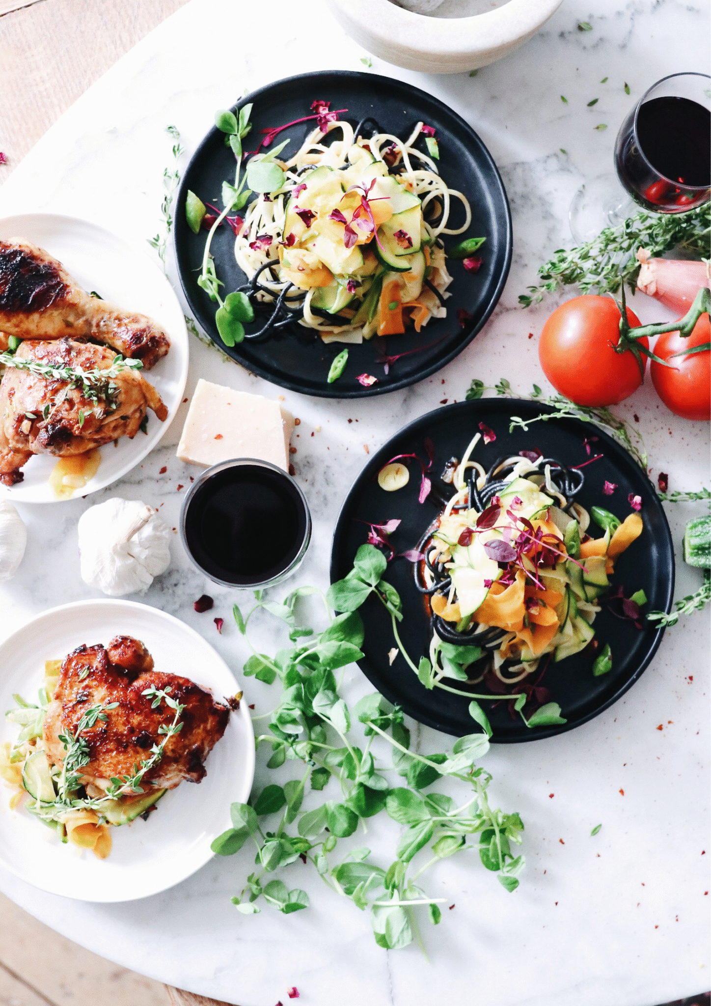 Zdrowe dania w stylu fit – pieczony kurczak i warzywne spaghetti z cukinii i marchwi, podane na marmurowym stole z dodatkiem świeżych ziół.